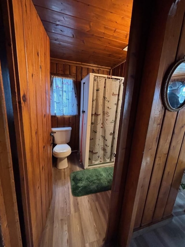 3974 W Houghton Lake Dr, Houghton Lake, MI 48629 - full bathroom with wooden walls, toilet, a shower stall, wooden ceiling, and wood finished floors