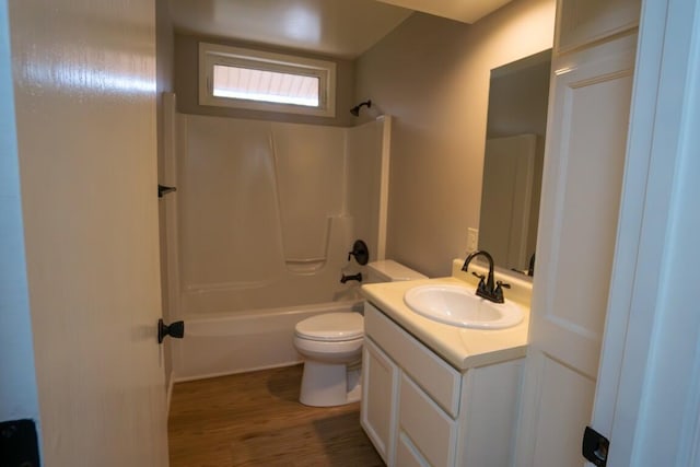 full bath with toilet, shower / bath combination, wood finished floors, and vanity