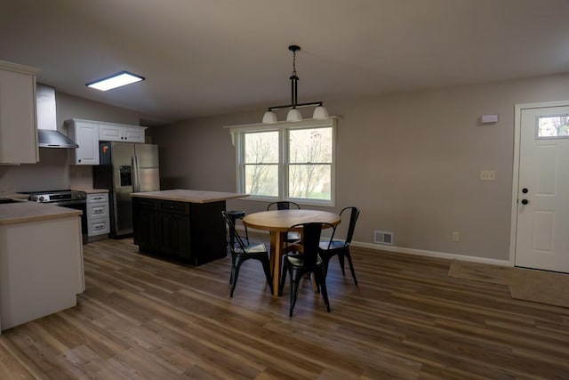 dining room with vaulted ceiling, visible vents, dark wood-style floors, and baseboards