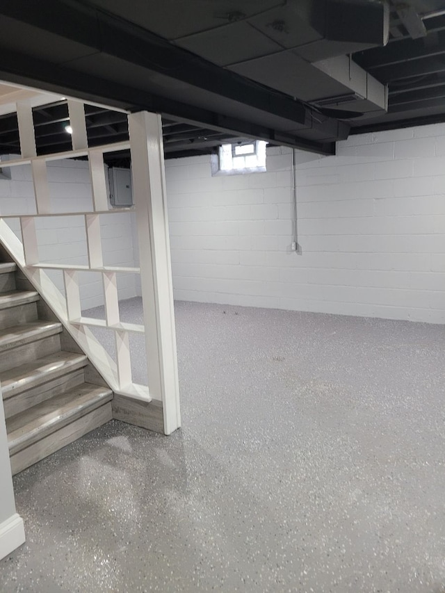 below grade area featuring concrete block wall and stairs
