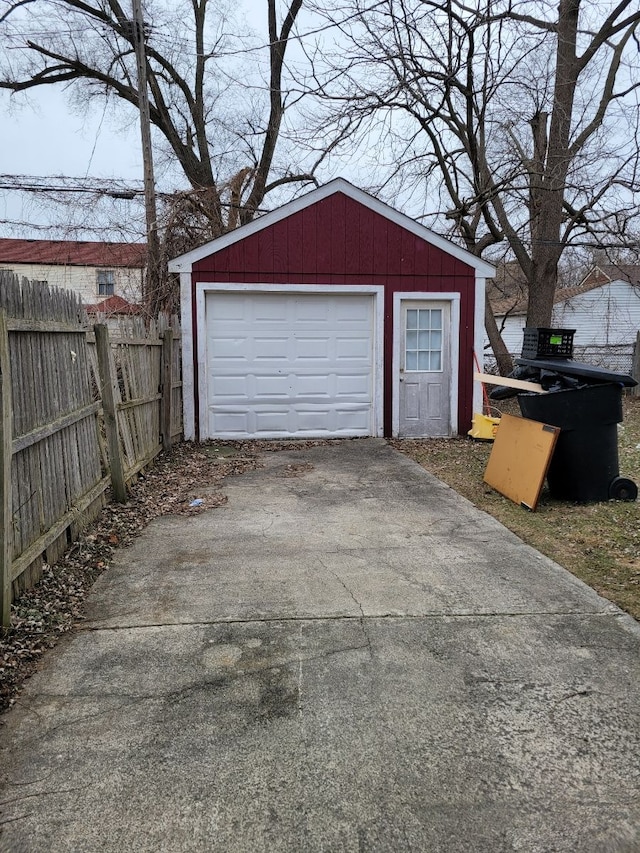 detached garage with fence and concrete driveway