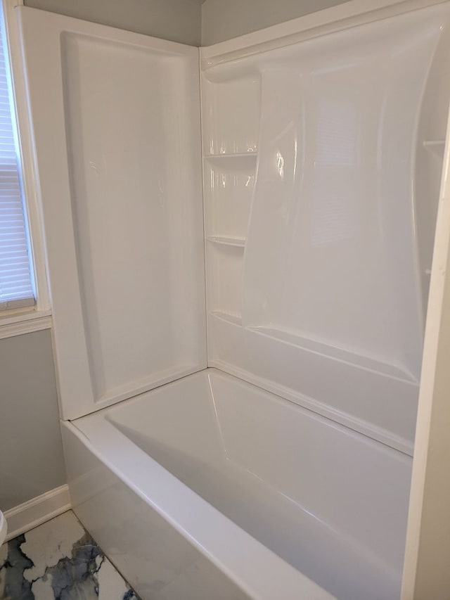 bathroom with walk in shower, a bath, and baseboards