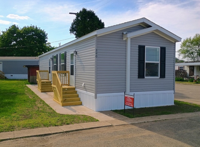 manufactured / mobile home featuring a front lawn