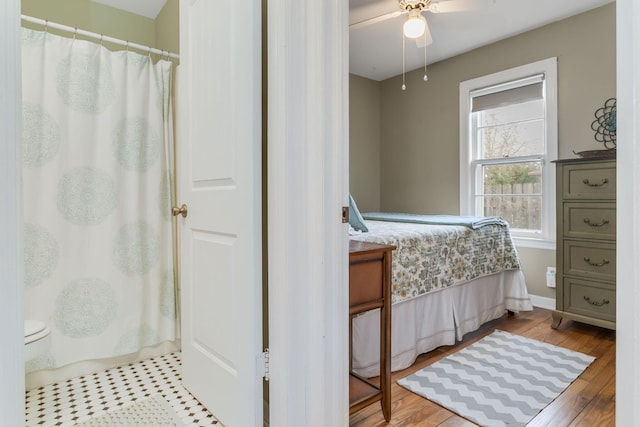 bedroom with wood finished floors, a ceiling fan, and baseboards
