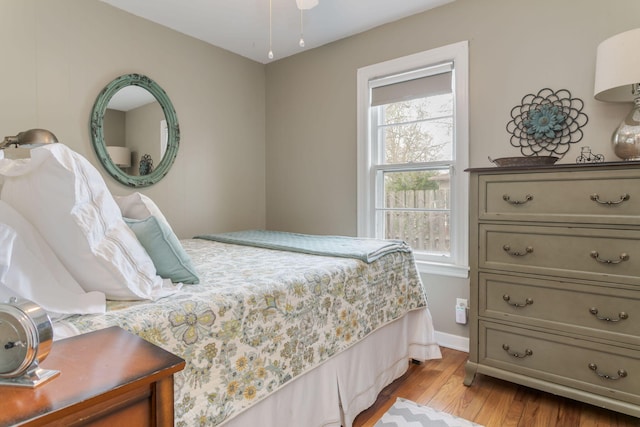 bedroom featuring light wood finished floors and baseboards