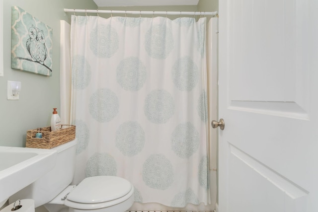 full bath featuring toilet, a shower with curtain, and a sink