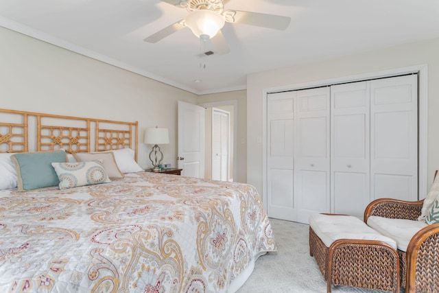 carpeted bedroom featuring visible vents, ornamental molding, a ceiling fan, and a closet