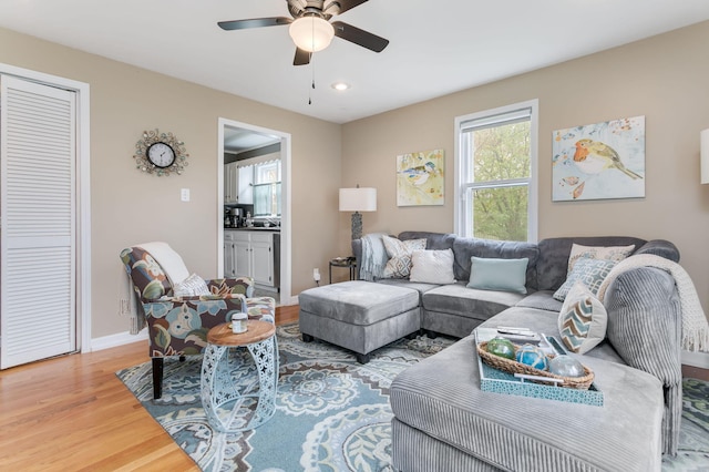 living area featuring wood finished floors, a ceiling fan, recessed lighting, and baseboards