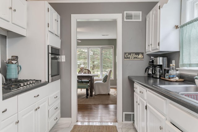 kitchen with dark countertops, visible vents, white cabinets, and stainless steel appliances