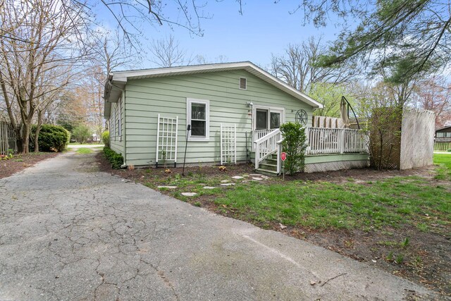 view of front facade featuring driveway and a deck