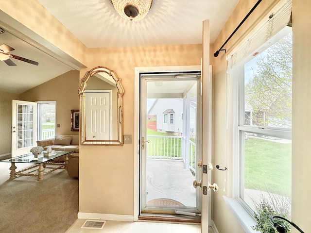 entryway with lofted ceiling, visible vents, a ceiling fan, and baseboards