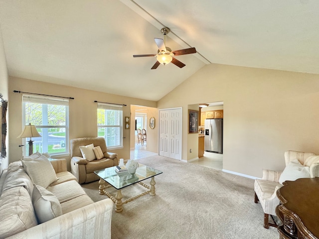 living area featuring light colored carpet, ceiling fan, baseboards, high vaulted ceiling, and beam ceiling