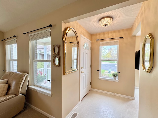 entrance foyer featuring visible vents, a healthy amount of sunlight, and baseboards