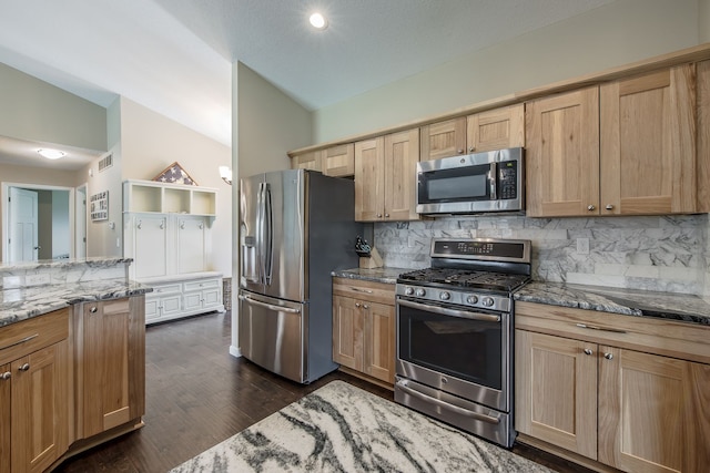 10207 Dodge Rd, Otisville, MI 48463 - kitchen with stainless steel appliances, light stone countertops, vaulted ceiling, and decorative backsplash