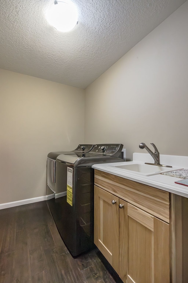 10207 Dodge Rd, Otisville, MI 48463 - laundry area featuring a textured ceiling, cabinet space, a sink, dark wood-style floors, and separate washer and dryer