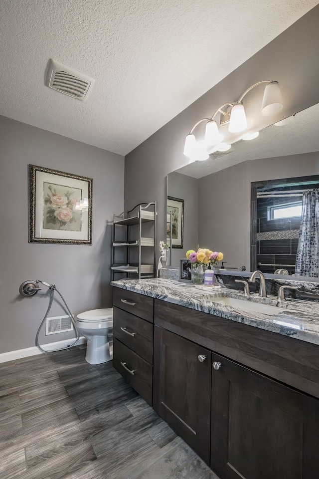 10207 Dodge Rd, Otisville, MI 48463 - bathroom with visible vents, vanity, wood finished floors, toilet, and baseboards