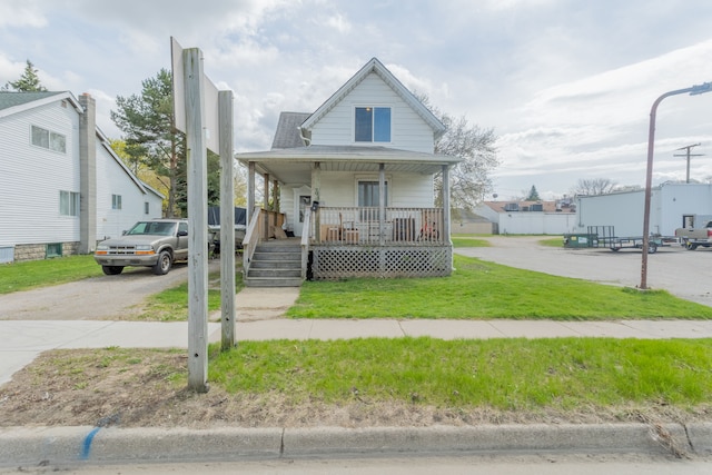 view of front of property featuring covered porch and a front lawn
