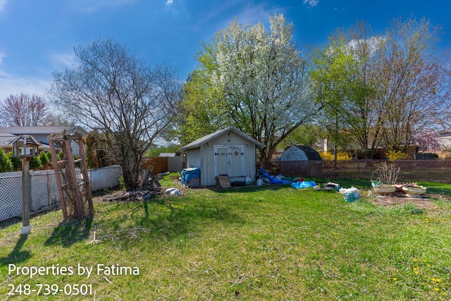 view of yard featuring a fenced backyard, an outbuilding, and a shed