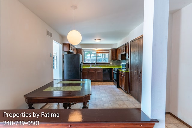 kitchen with visible vents, pendant lighting, tasteful backsplash, a sink, and black appliances