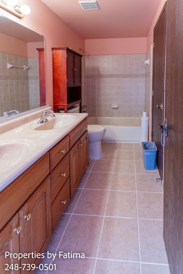 bathroom featuring a sink, toilet, double vanity, tile patterned floors, and visible vents
