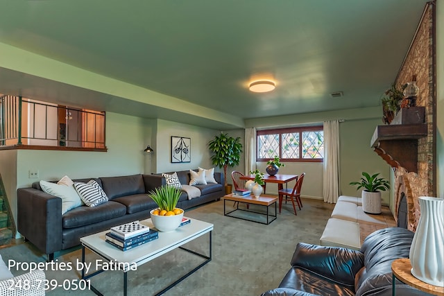 living room featuring visible vents, baseboards, and a fireplace