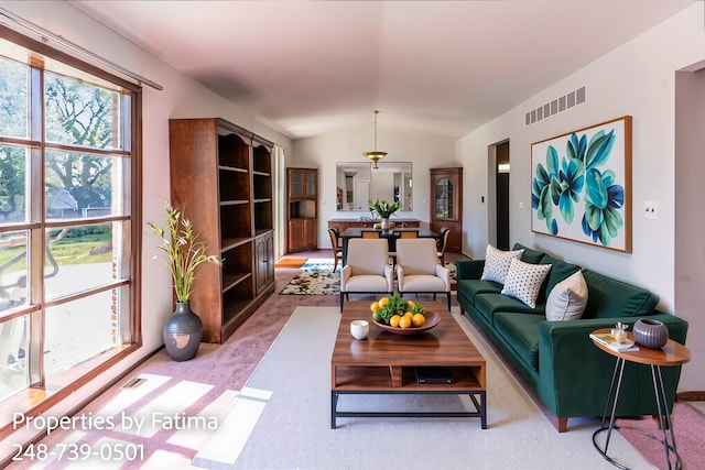 living area featuring visible vents and lofted ceiling