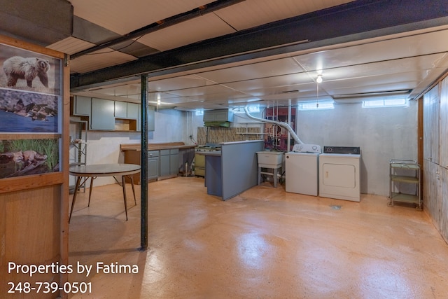 basement featuring independent washer and dryer and a sink