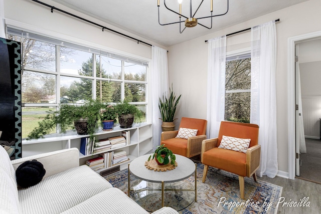 sitting room with wood finished floors, a chandelier, and baseboards