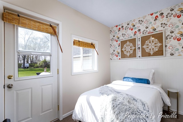 bedroom with baseboards, wainscoting, multiple windows, and wallpapered walls