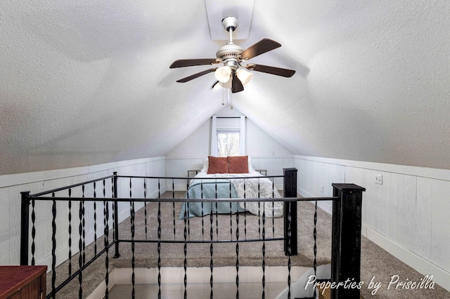 additional living space with a ceiling fan, carpet floors, a textured ceiling, and vaulted ceiling