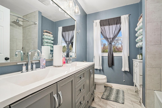 bathroom featuring a healthy amount of sunlight, marble finish floor, and a sink