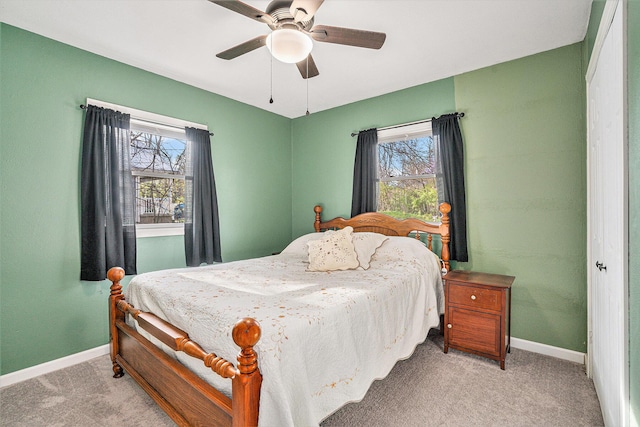 bedroom with multiple windows, ceiling fan, carpet, and baseboards