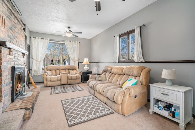 living area with a ceiling fan, carpet floors, a textured ceiling, and a fireplace