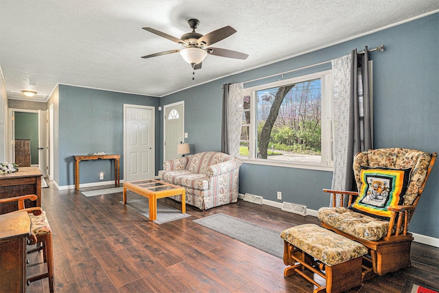 living room with wood finished floors, visible vents, and baseboards