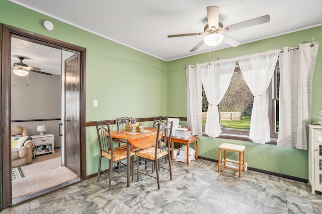 dining space featuring ornamental molding, a ceiling fan, and baseboards