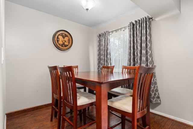 dining space with baseboards and wood finished floors