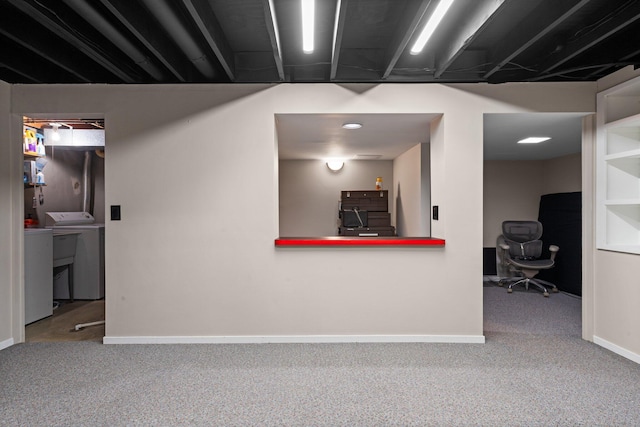 finished basement with carpet flooring, washing machine and clothes dryer, and baseboards