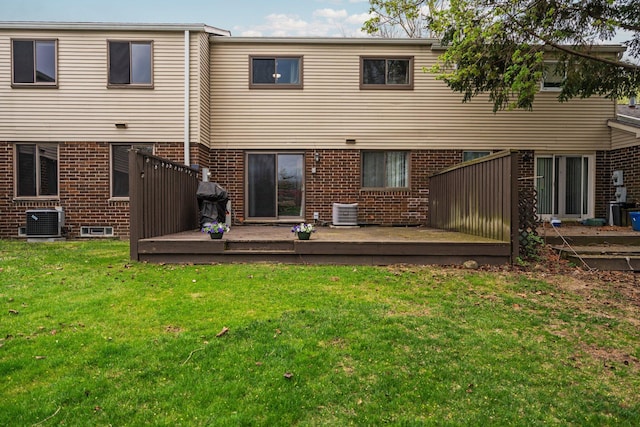 rear view of house with a deck, central AC unit, and brick siding