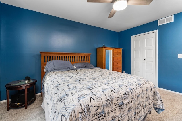 bedroom featuring a closet, a ceiling fan, visible vents, carpet, and baseboards