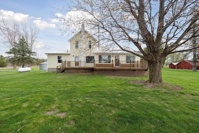 rear view of house featuring a deck and a lawn