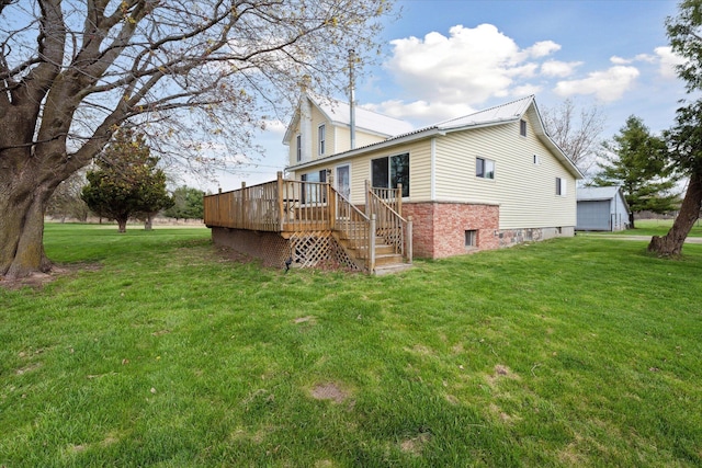 back of house featuring a deck, brick siding, stairway, and a yard