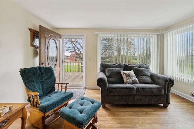 living area featuring light wood-style floors and baseboards