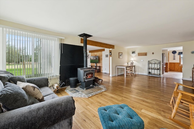 living area with wood finished floors and a wood stove