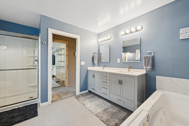 full bathroom featuring a jetted tub, a shower stall, double vanity, and a sink