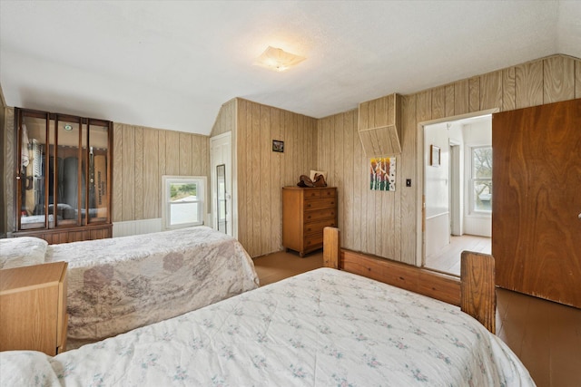 bedroom featuring lofted ceiling, wood finished floors, and multiple windows