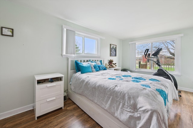 bedroom featuring multiple windows, wood finished floors, and baseboards