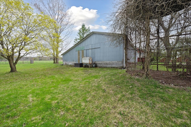 view of yard with a pole building, an outbuilding, and fence
