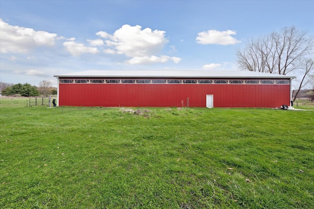 view of pole building with fence and a lawn