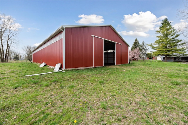 view of pole building with fence and a yard