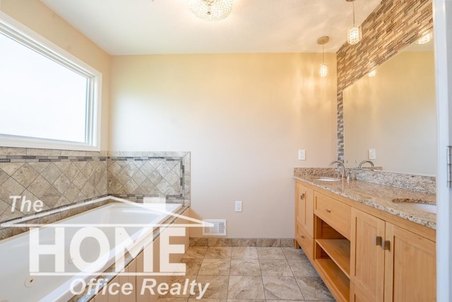 full bathroom with a sink, double vanity, visible vents, baseboards, and a garden tub